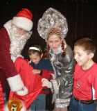 Дед Мороз и Снегурочка вручают подарки детям